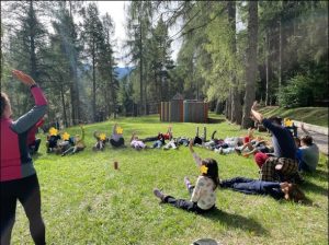bambini in cerchio che svolgono un'attività con le mani in alto